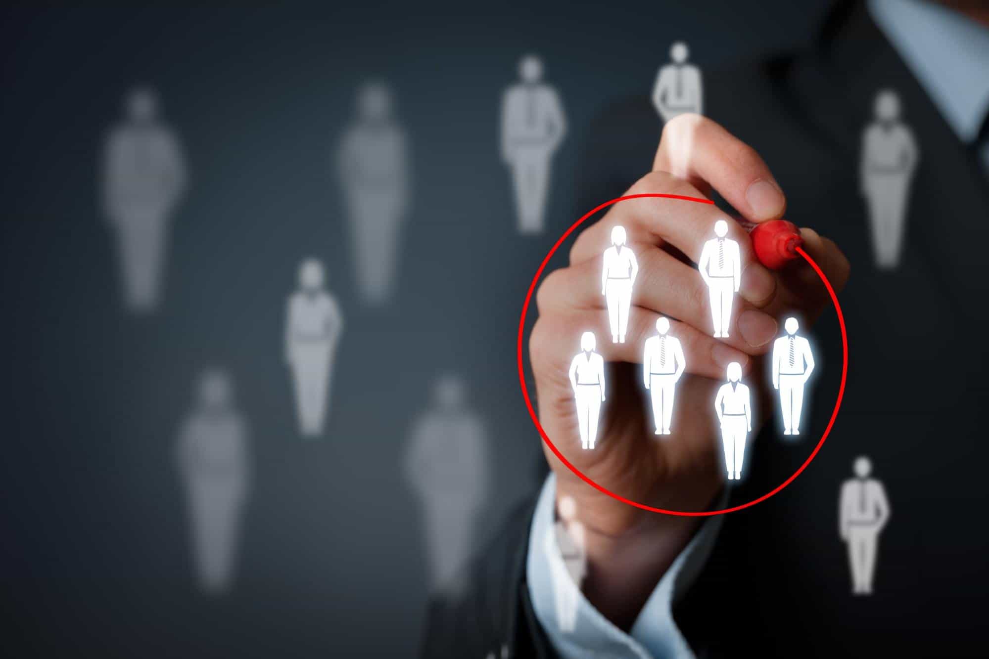 Using a marker, a hand outlines a group of human avatars