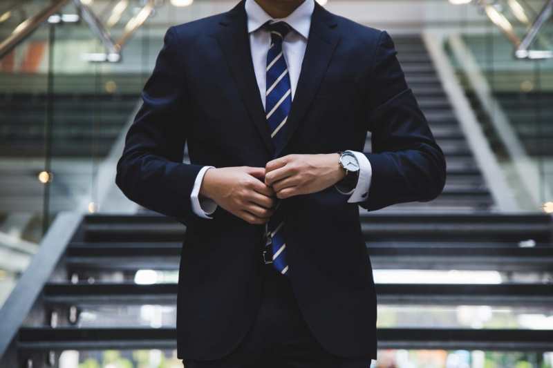 A businessman in a suit standing on a staircase.
