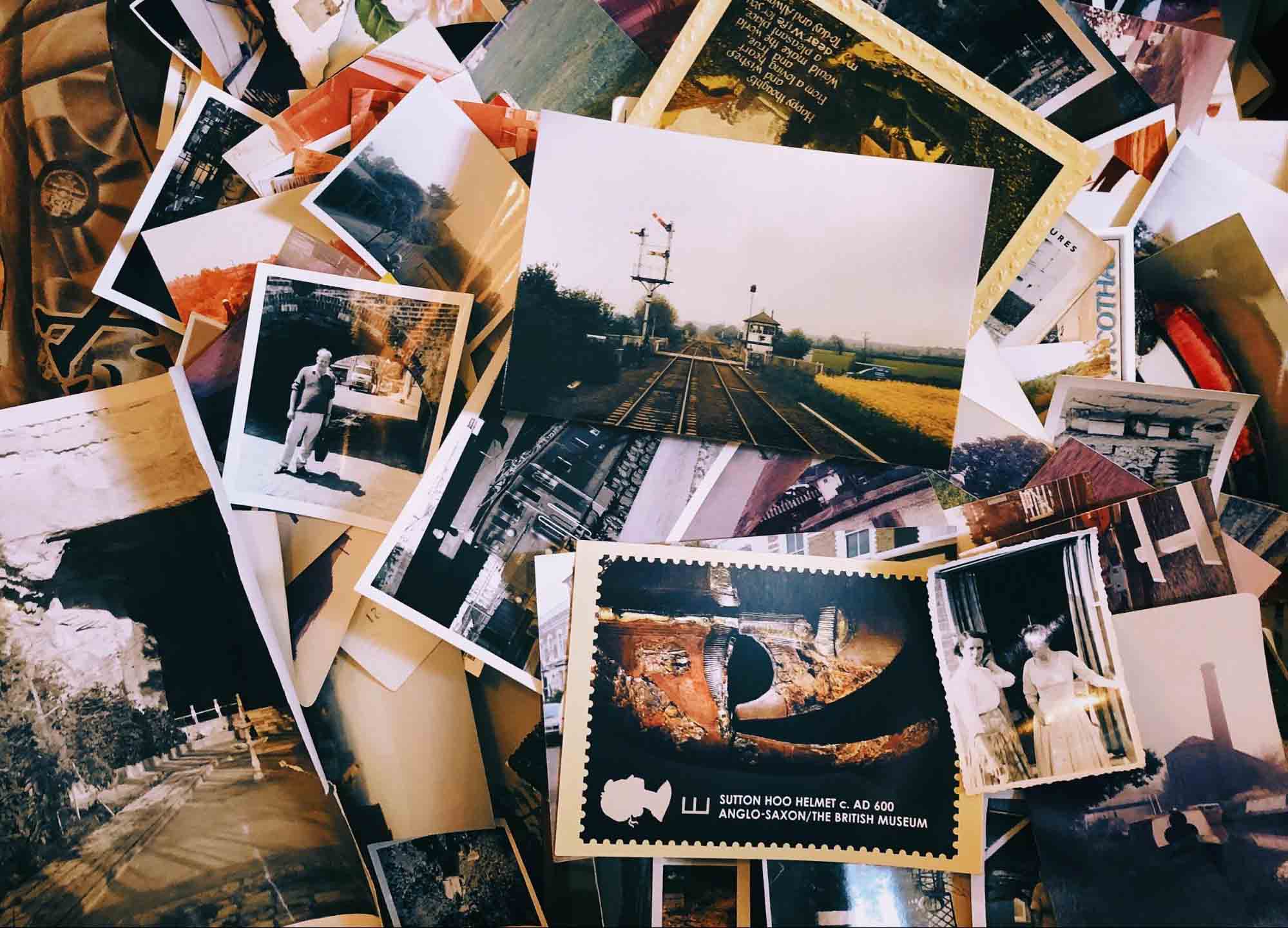 photos A pile of old photos and postcards on a table.