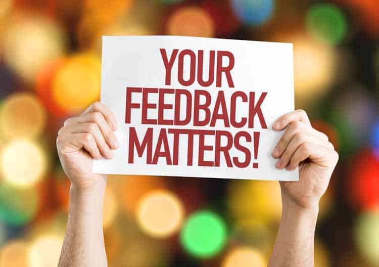 A person holding up a sign that says your feedback matters.