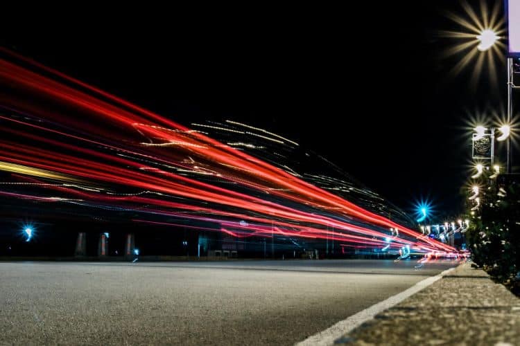 A long exposure image of a city street at night.