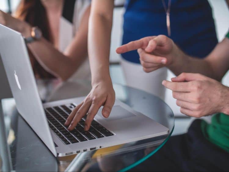 A group of people working on a laptop.