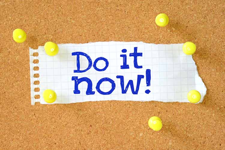A note with the word do it now pinned to a cork board.