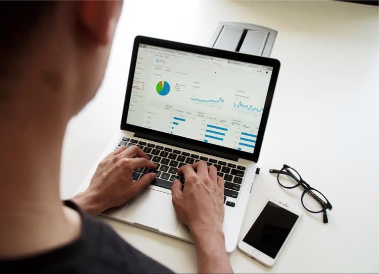A person using a laptop with a graph on it.