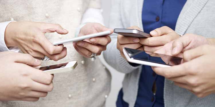A group of people holding cell phones in their hands.