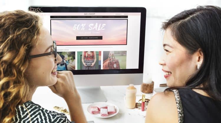 Two women looking at a website on a computer.
