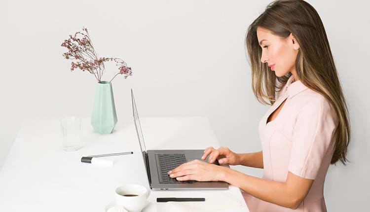 A woman working on her laptop at a desk.