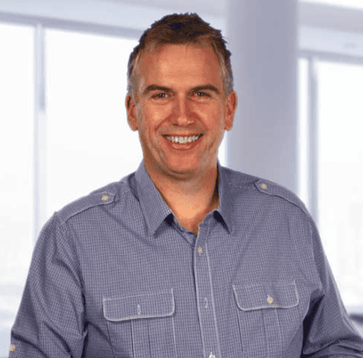 A smiling man in a blue shirt.