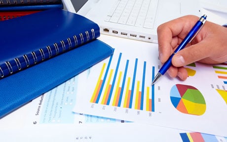 A hand holding a pen over a graph.