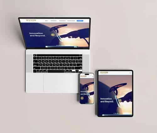 Display showing a laptop, tablet, and smartphone with the same website open, featuring an image of a person holding a car charging plug and the text "Innovation and Beyond.