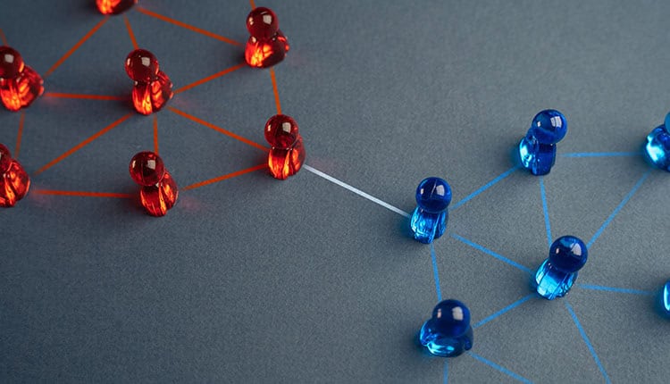 Red and blue game pieces are grouped and connected by lines, with one line linking the two groups, representing communication or connection between networks.